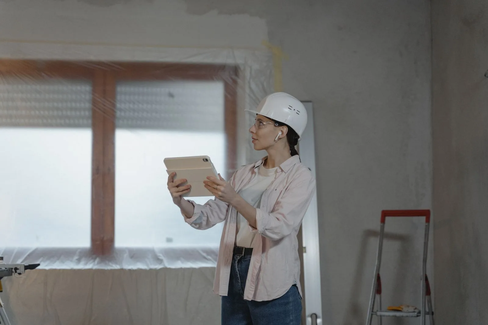 Inspector holding a tablet in a room under renovation