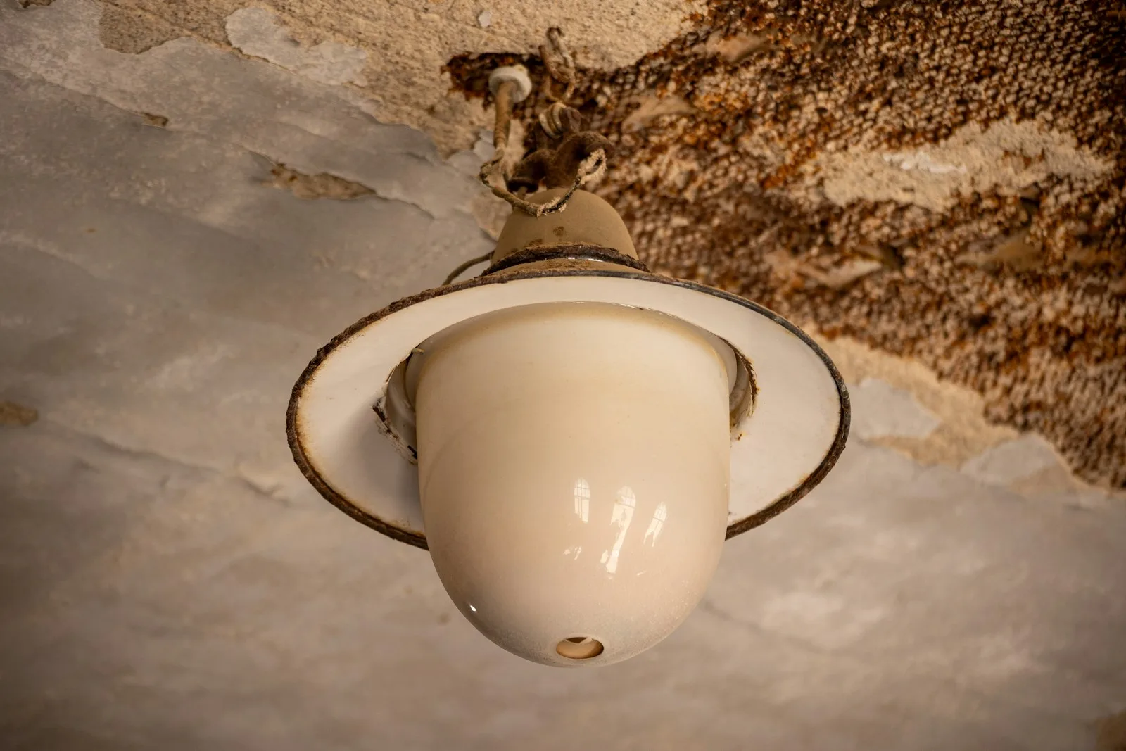 Water-damaged, stained ceiling around a light fixture